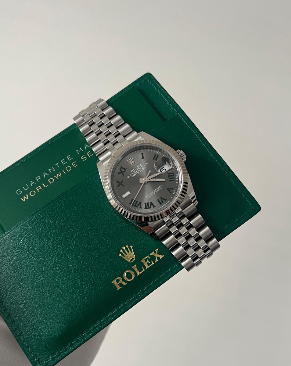 Rolex Datejust 36 with a slate Roman dial resting on its Rolex guarantee wallet